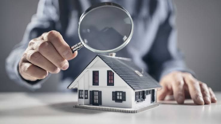 Magnifying glass over a small model house on a table
