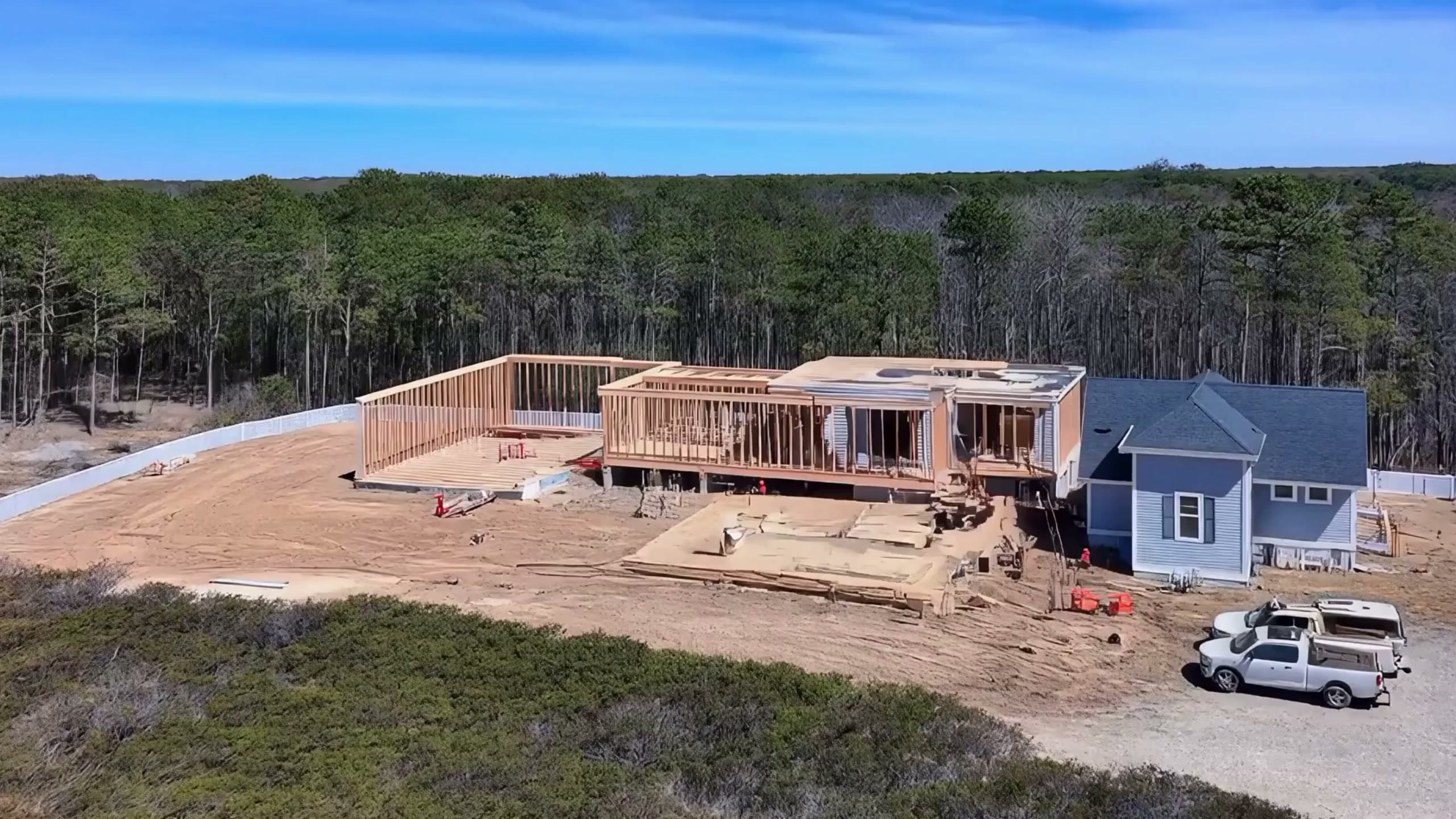 Aerial view of a new home under construction on a wooded Outer Banks lot